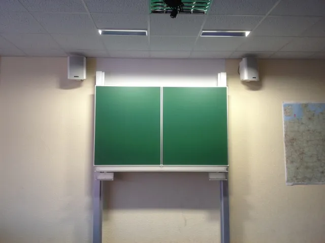 Zweiteilige grüne Tafel an Hubsäulen in einem Klassenzimmer